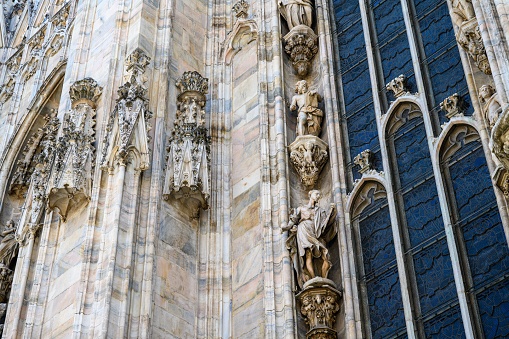 MIlan, Italy – June 18, 2023: Summer day of the Milan Cathedral with the long narrow windows on the side.
