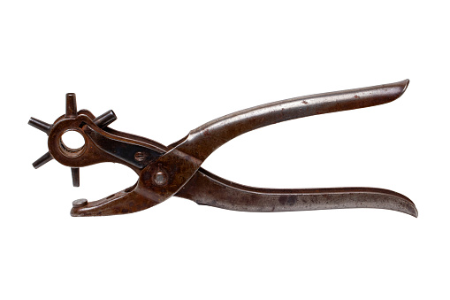 Tailoring accessories. Closeup of a antique adjustable Steel punch pliers or hole punch tool isolated. Clipping path. Tools from tailor, saddler or cobbler.