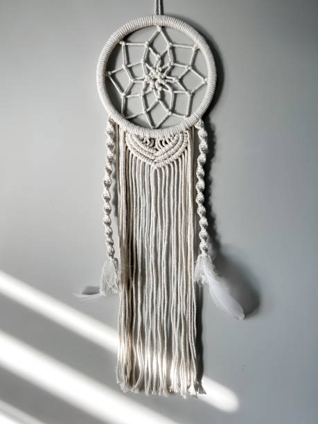 istock Handmade cotton macrame Dreamcatcher on a gray wall background. Traditional amulet to protect sleep. Home decor made from lace on the wall. Women's hobby. 1728125593
