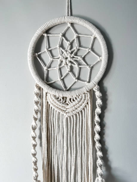 istock Handmade cotton macrame Dreamcatcher on a gray wall background. Traditional amulet to protect sleep. Home decor made from lace on the wall. Women's hobby. 1728125595