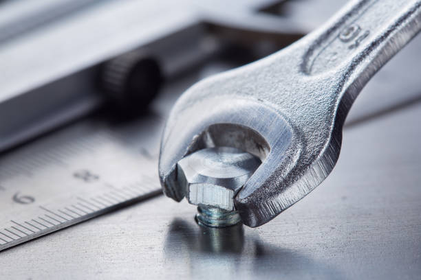istock Wrench tightens bolt in steel billet. Spanner, bolt, screw and nuts. 1728143888