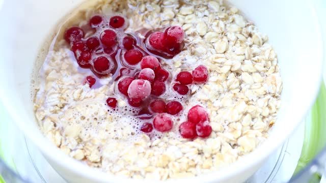 Oatmeal porridge with lingonberries in a white plate