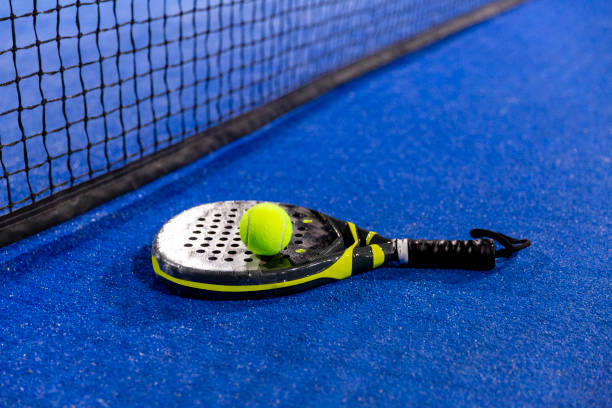 istock Padel racket on a padel blue court with a ball 1728163704