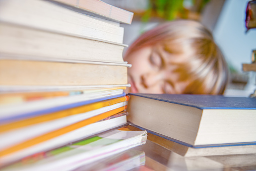 Cute Child and a lot of Books on the Table