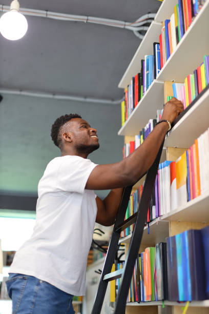 istock A serious young student in a university library, surrounded by books on a bookshelf, makes thoughtful choices for education. 1728208147