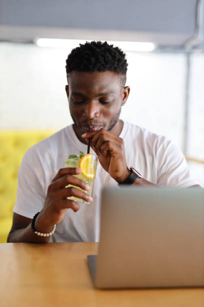 istock A confident young businessman working on his laptop in a modern cafe while enjoying a cocktail. 1728208152