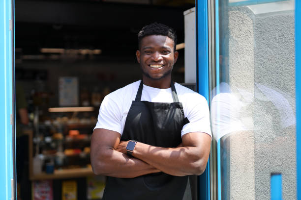 istock A confident and happy young businessman, owner of a modern retail store, stands with folded arms, exuding professionalism. 1728208708