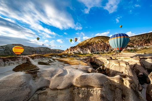 Hot air balloons flying over geological formations
