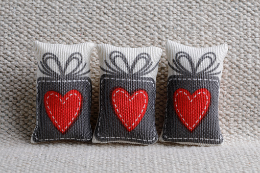 Top view of red heart in a house decorated with small hearts on wooden background. Valentine's day. Home sweet home concept.