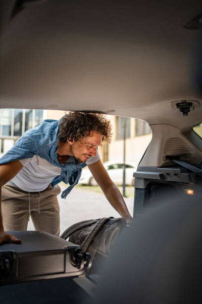 istock Man is packing luggage in a car trunk 1728242431