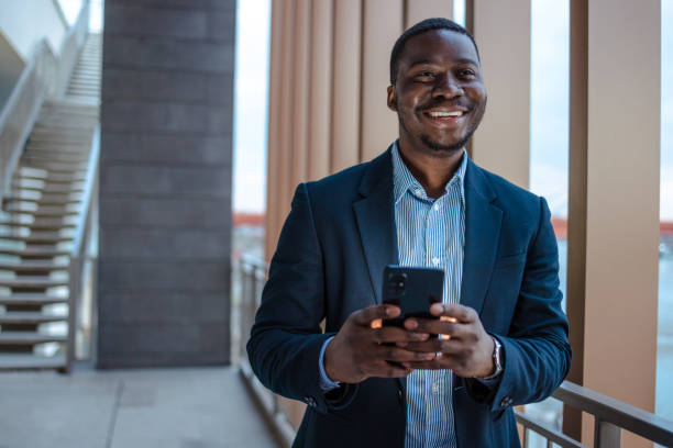 Elegant African-American young man using smart phone phone in the city stock photo