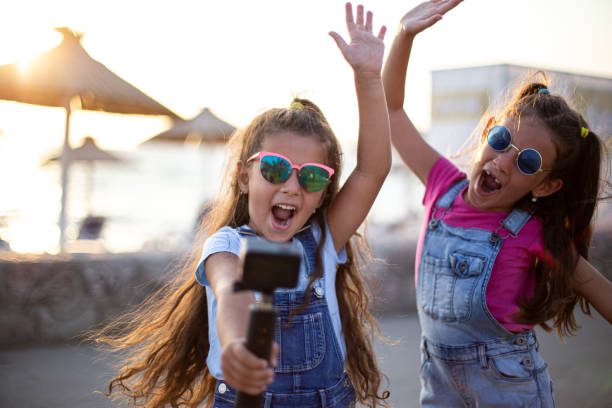 istock Young girls enjoy in making selfie on beach in rollerblading 1728293333