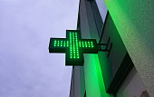 Green pharmacy electric sign outside.