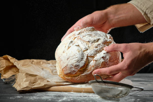 istock the man holds a fresh loaf of bread in his hands 1728302814