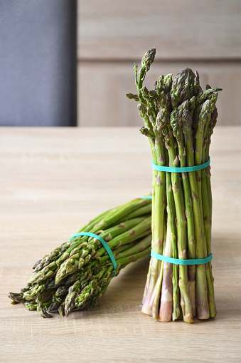 Close up of green asparagus bunches on wooden background