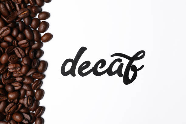 Word Decaf and coffee beans on white background, top view