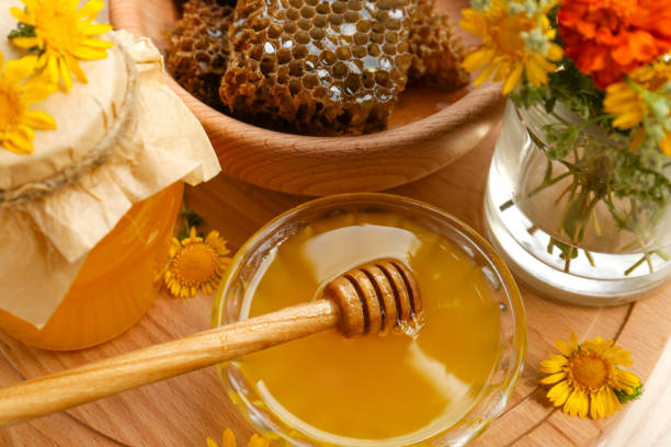 istock Delicious honey, combs and different flowers on wooden board 1728323333