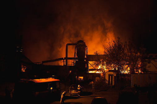 Kirov, Russia - 10.01.2023: Large scale night fire at a factory or sawmill. Fire brigade with fire trucks.