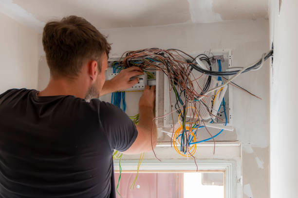 istock A male electrician works in a switchboard with an electrical connecting cable. 1728336064
