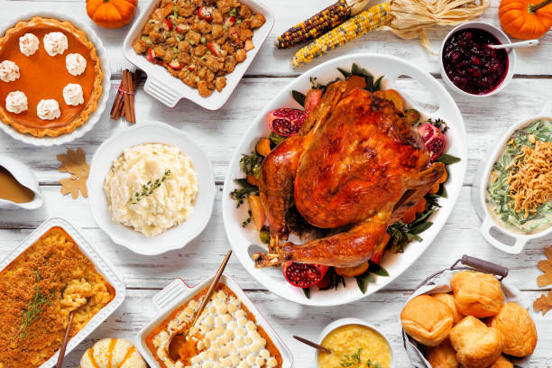 istock Delicious Thanksgiving turkey dinner. Above view table scene on a rustic white wood background. Turkey, mashed potatoes, stuffing, pumpkin pie and sides. 1728350610