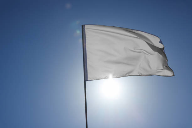 istock White flag fluttering against blue sky on sunny day 1728351733