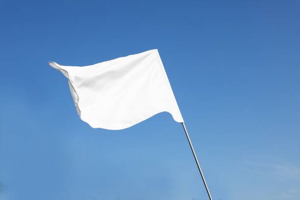 istock White flag fluttering against blue sky on sunny day 1728352253