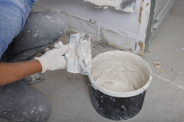 istock Worker plastering wall with putty knife indoors, closeup 1728368836