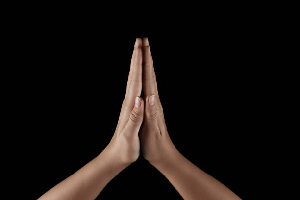 istock Woman holding hands clasped while praying on black background, closeup 1728399933