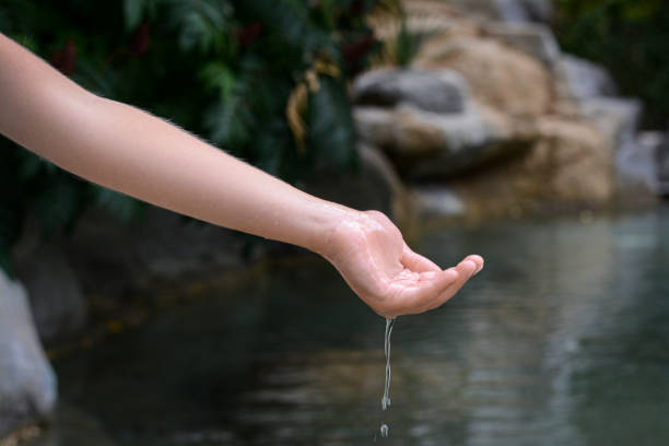 istock Kid pouring water from hand in pond, closeup 1728399983