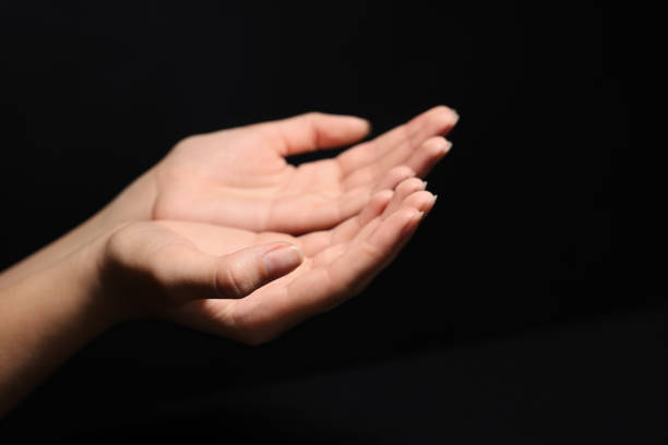 istock Woman stretching hands towards light in darkness, closeup 1728400972