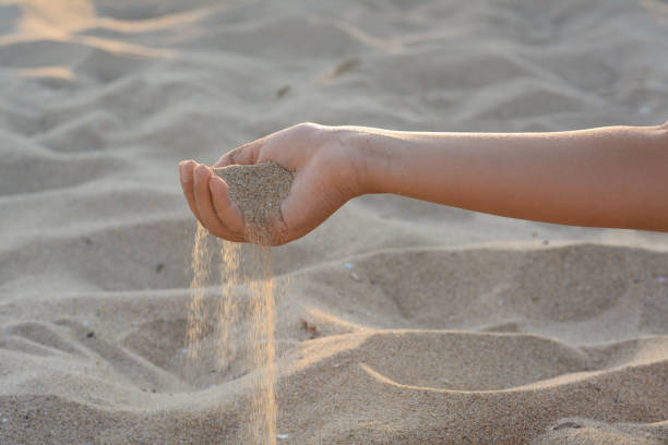 istock Girl pouring sand from hand outdoors, closeup. Fleeting time concept 1728401503