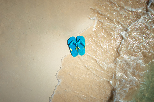 Flip Flops on the Sand at the Beach. Summer Holiday and Vacation Concept.