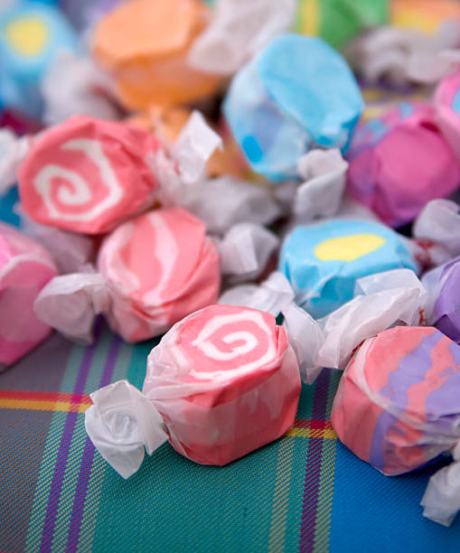 verschiedene eingewickelt salzwasser-toffee candy hintergrund auf picknick-decke - taffy stock-fotos und bilder