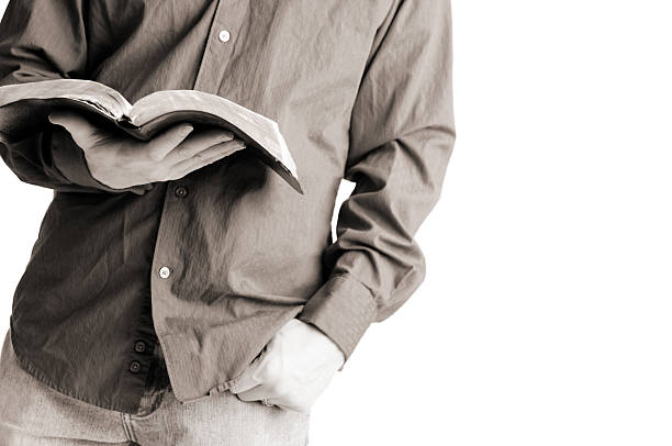 leger gekleidete christian mann hält offene bibel - bible holding reading book stock-fotos und bilder