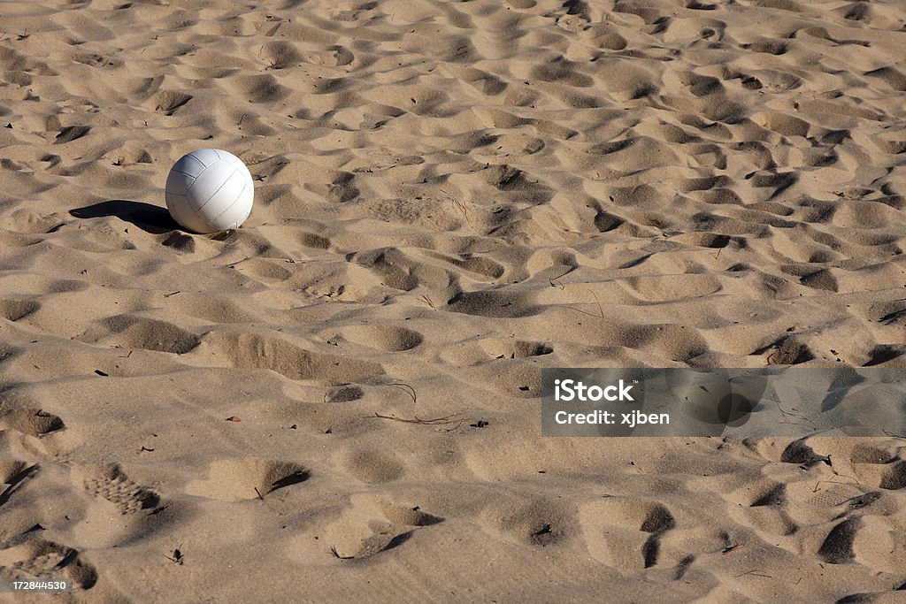 Volleyball in the Sand Single volleyball resting in the sand on the beach court. Activity Stock Photo