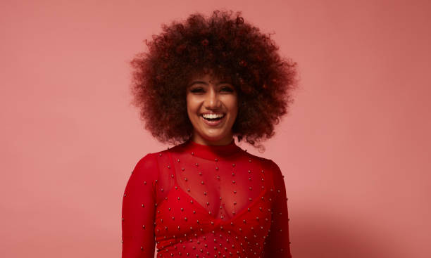 istock Curly-haired mixed race young woman in red. 1728454082