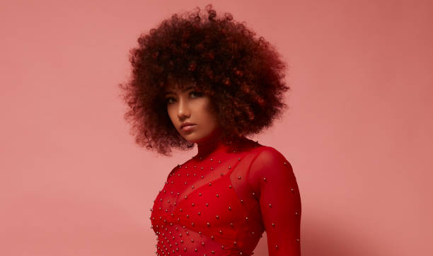 istock Curly-haired mixed race young woman in red. 1728454084