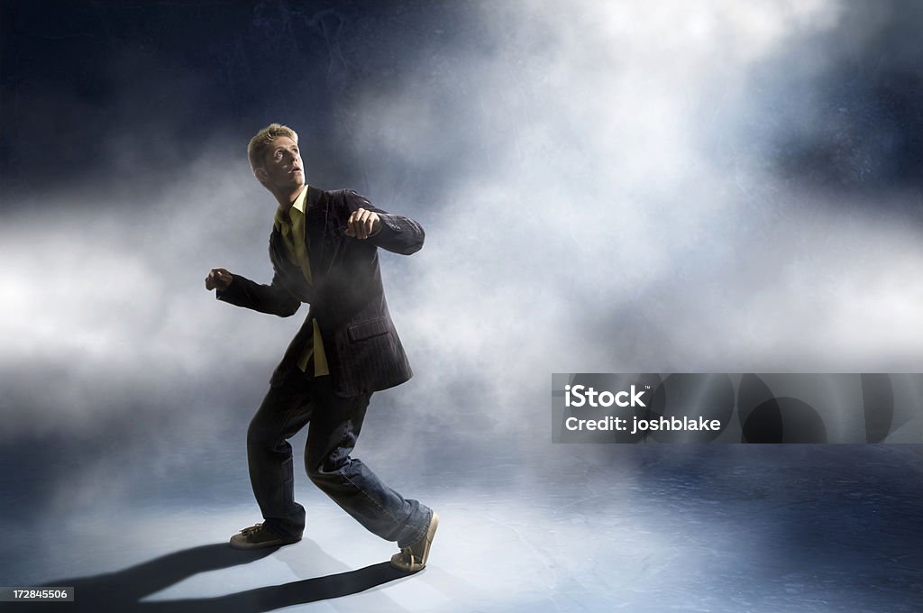 Man in a suit looking up in a ready-to-run stance male gets caught in the lights Men Stock Photo
