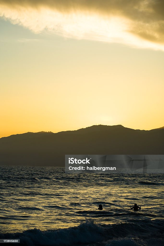 Nadadores en la bahía de Santa Mónica al atardecer - Foto de stock de Anochecer libre de derechos