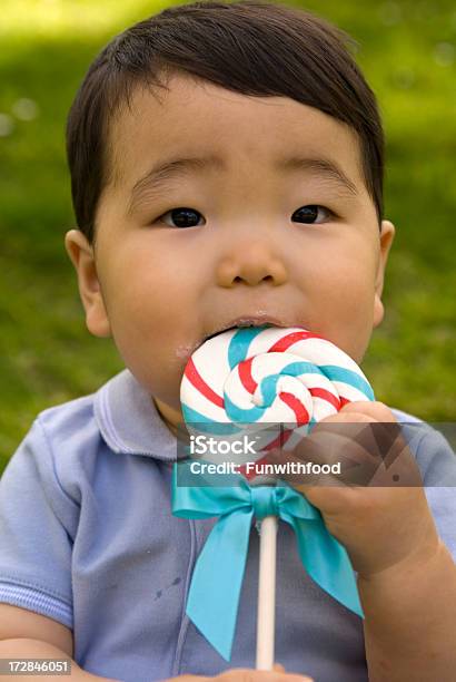 Bambino Asiatico Coreano Bambino Mangiare Leccalecca Di Zucchero - Fotografie stock e altre immagini di Erba