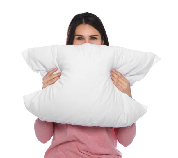 istock Young woman covering face with pillow on white background 1728464276