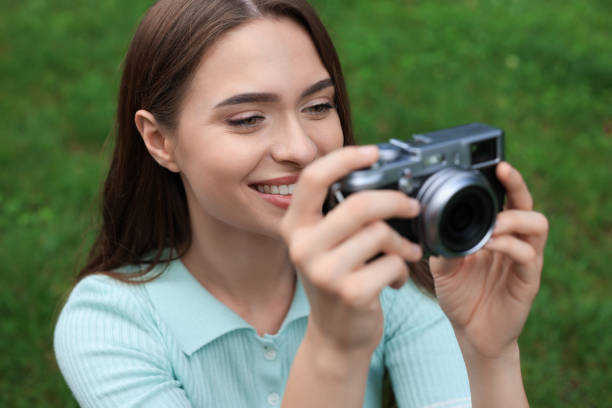 istock Young woman with camera taking photo outdoors. Interesting hobby 1728465335