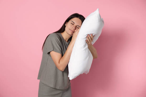 istock Sleepy young woman with soft pillow on pink background 1728466471