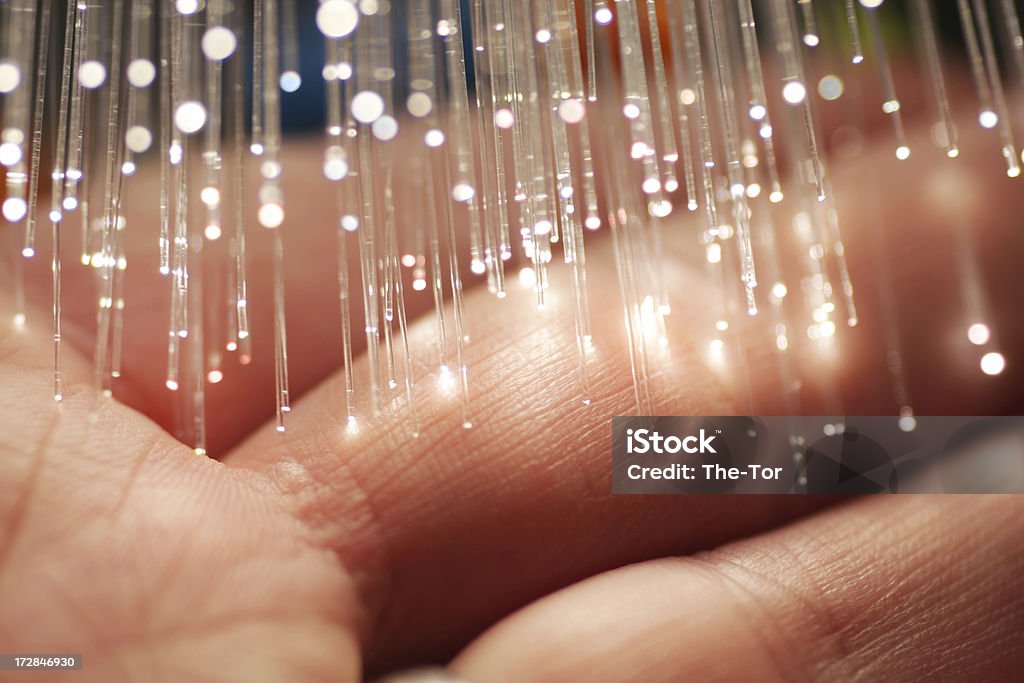 Fiber Optics & Hand Fiber optics spreading light on a human hand. Fiber Optic Stock Photo