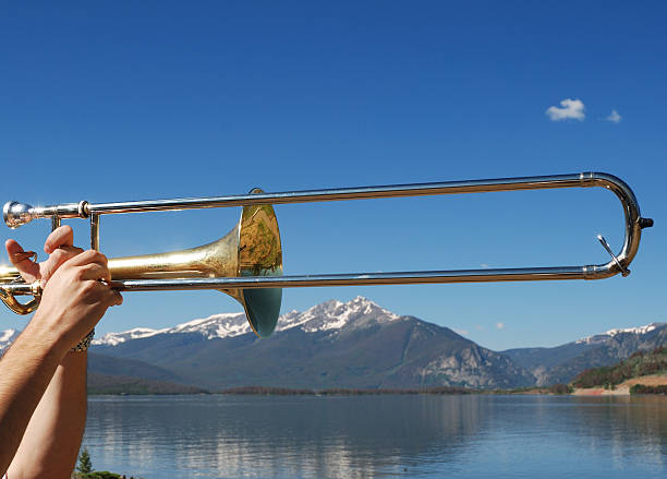 Trombone in the Mountains A trombone held up and ready to play in the Rocky Mountains of Colorado. tenmile range stock pictures, royalty-free photos & images