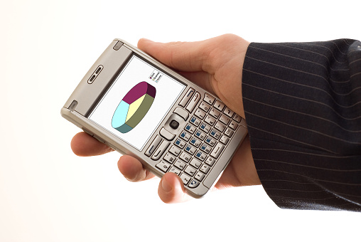 Phone in a hand with a diagram on screen.