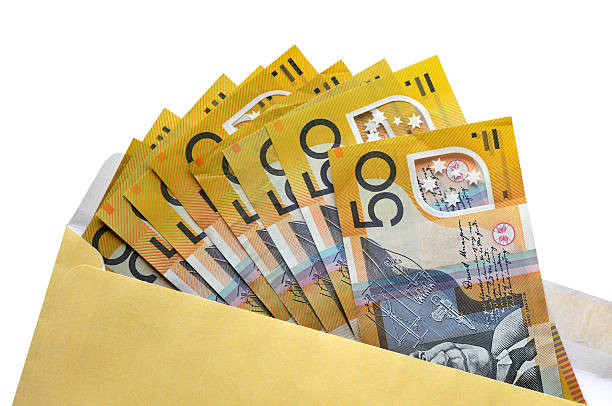 Open envelope of Australian fifty dollar notes Australian $50 dollar notes coming out of an envelope isolated on white background australian dollar stock pictures, royalty-free photos & images