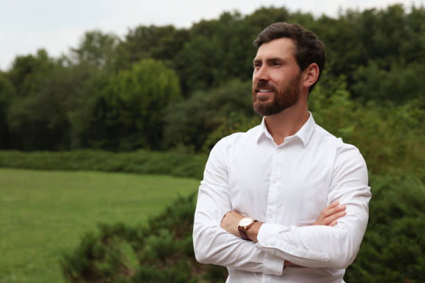 Portrait of handsome bearded man in park, space for text