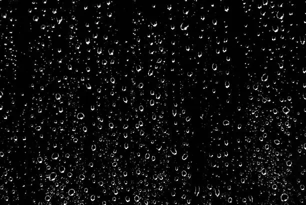 Drops of rain on glass in black and white.... background.