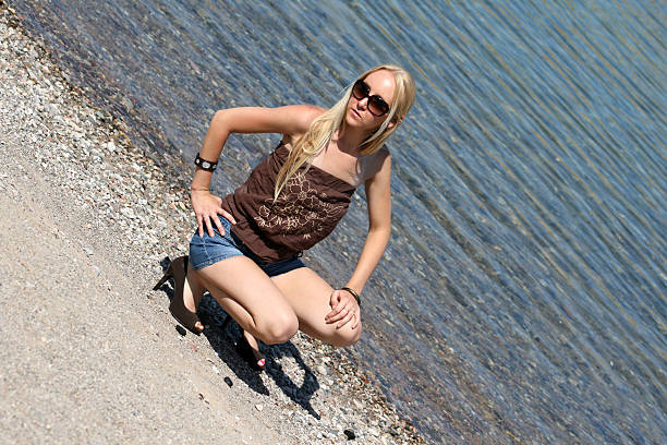 One woman, beautiful young lady relaxing in the sea in sunset on vacation, rear view.
